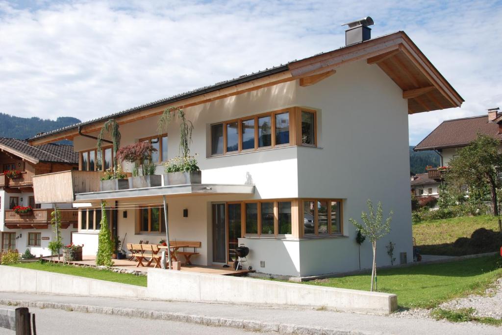 a white house with a patio and a table at Appartment Bichler in Hopfgarten im Brixental
