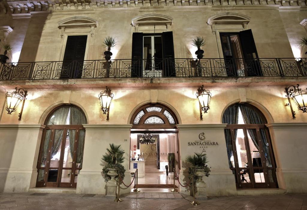 a store front with a building with palm trees on it at Suite Hotel Santa Chiara in Lecce