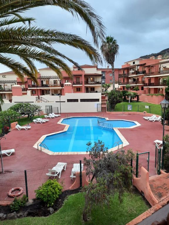 a large swimming pool with lounge chairs and a resort at Starfish playa in Los Cancajos