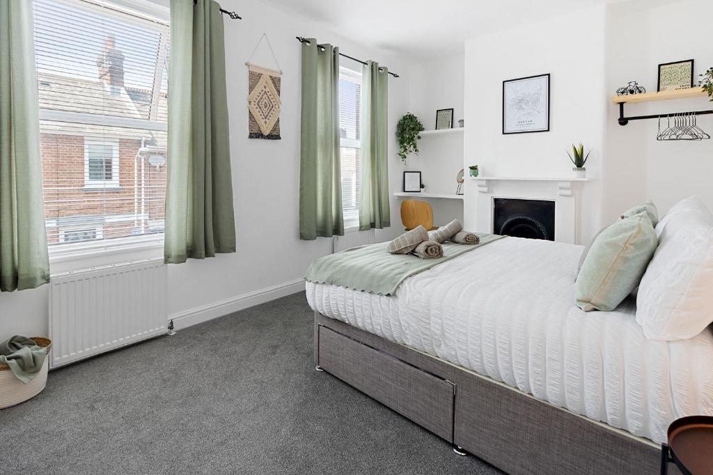a white bedroom with a bed and a fireplace at City Reach by Staytor Accommodation in Exeter