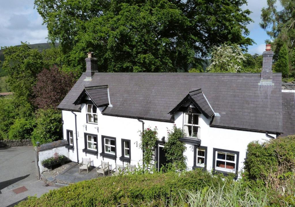 a white house with a black roof at The Stables in Corwen