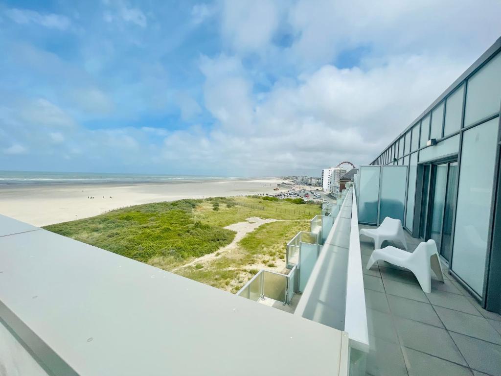 - un balcon avec 2 chaises blanches et la plage dans l'établissement VUE MER INCROYABLE - 3 Chambres - PARKING 2 PLACES - WIFI, à Berck-sur-Mer