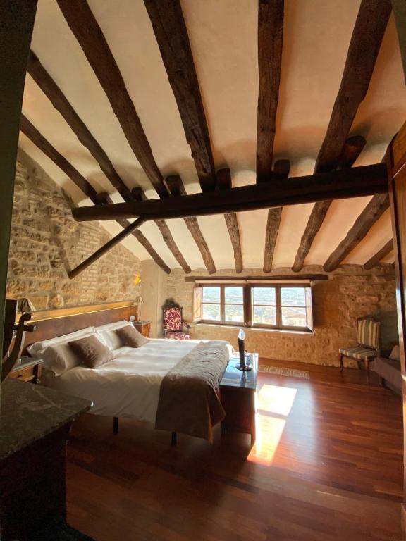 a bedroom with a large bed with a wooden ceiling at Hotel del Sitjar in Calaceite