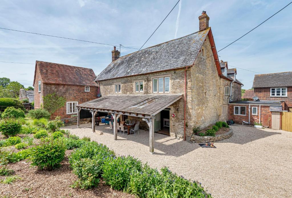 an old brick building with a wooden roof at Lower Fifehead Farm in Sturminster Newton