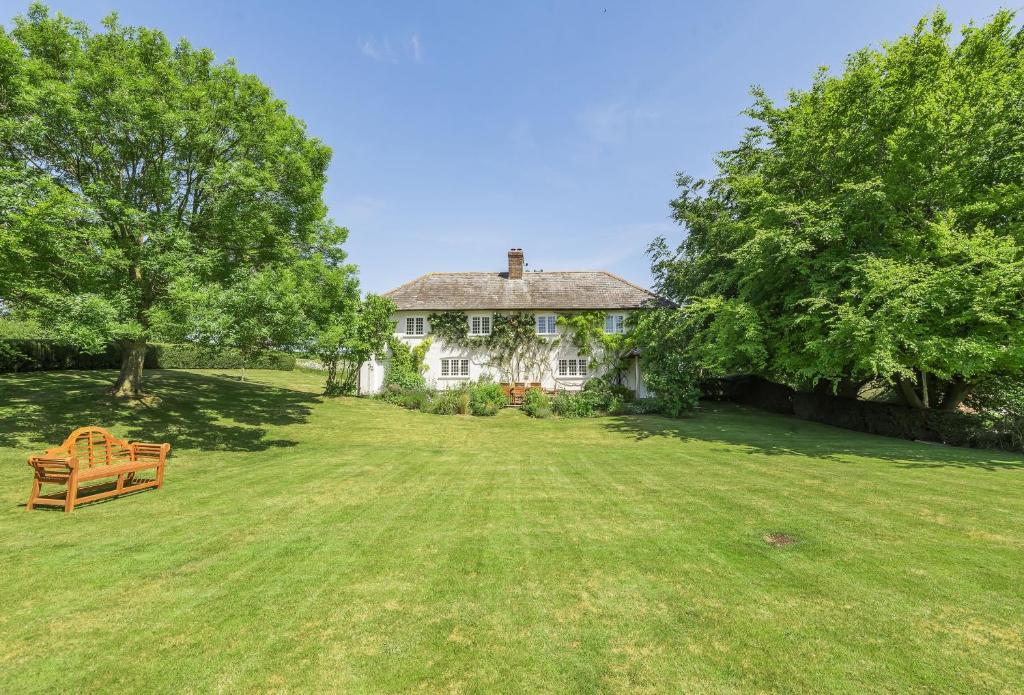 een wit huis met een bank in de tuin bij Creaky Cottage in Dorchester
