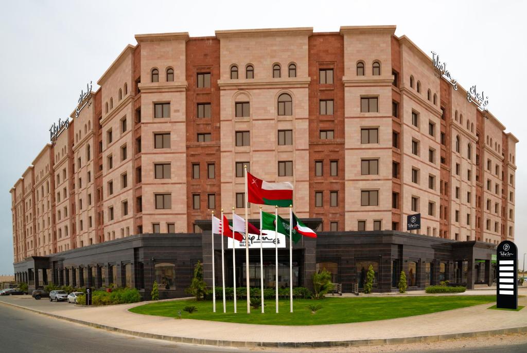 um edifício com quatro bandeiras à sua frente em Tulip Inn Majan Hotel em Salalah