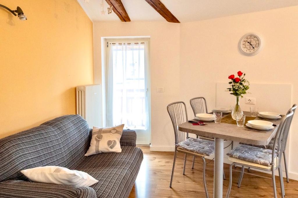 uma sala de estar com uma mesa e um sofá em Appartamento Sissi, romantico in centro em Levico Terme
