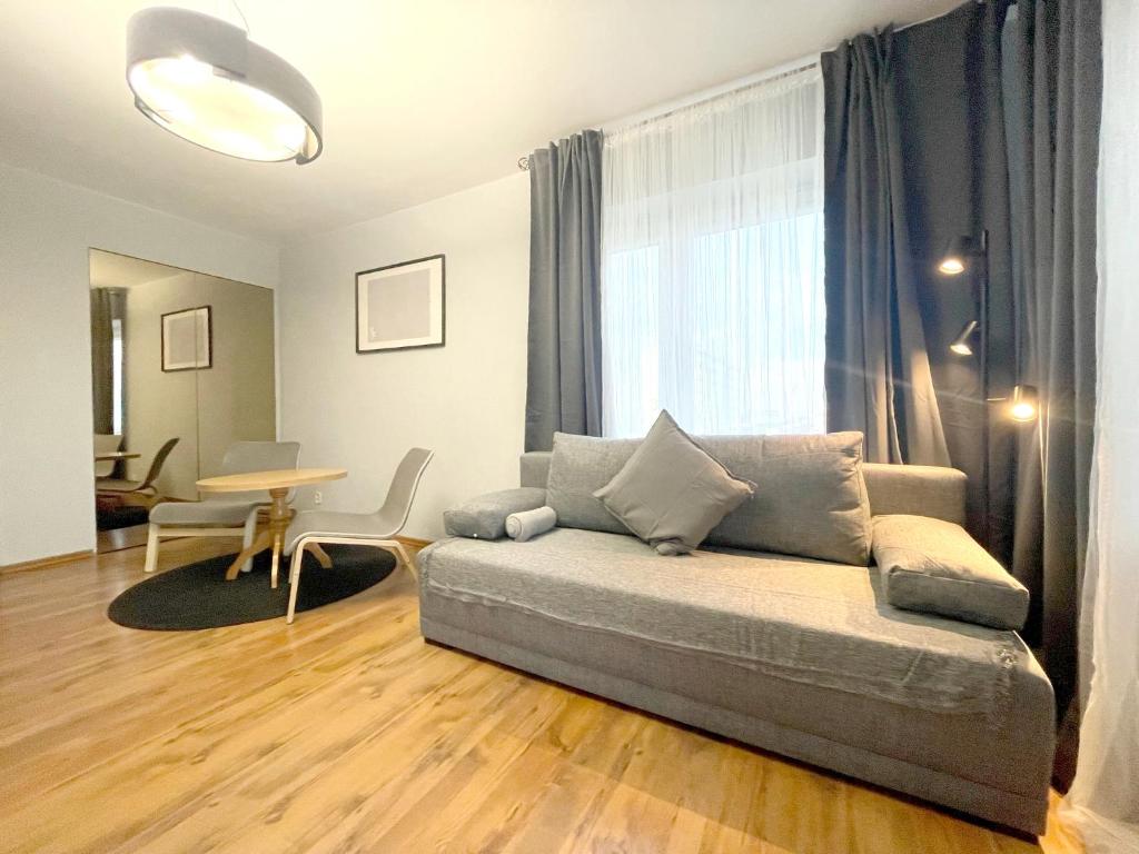 ein Wohnzimmer mit einem Sofa und einem Tisch in der Unterkunft 11 Gdynia Morska - Apartament Mieszkanie dla 5 osób in Gdynia