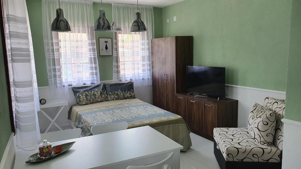 ein kleines Schlafzimmer mit einem Bett und einem TV. in der Unterkunft TOP 3 Apartments in Strumica