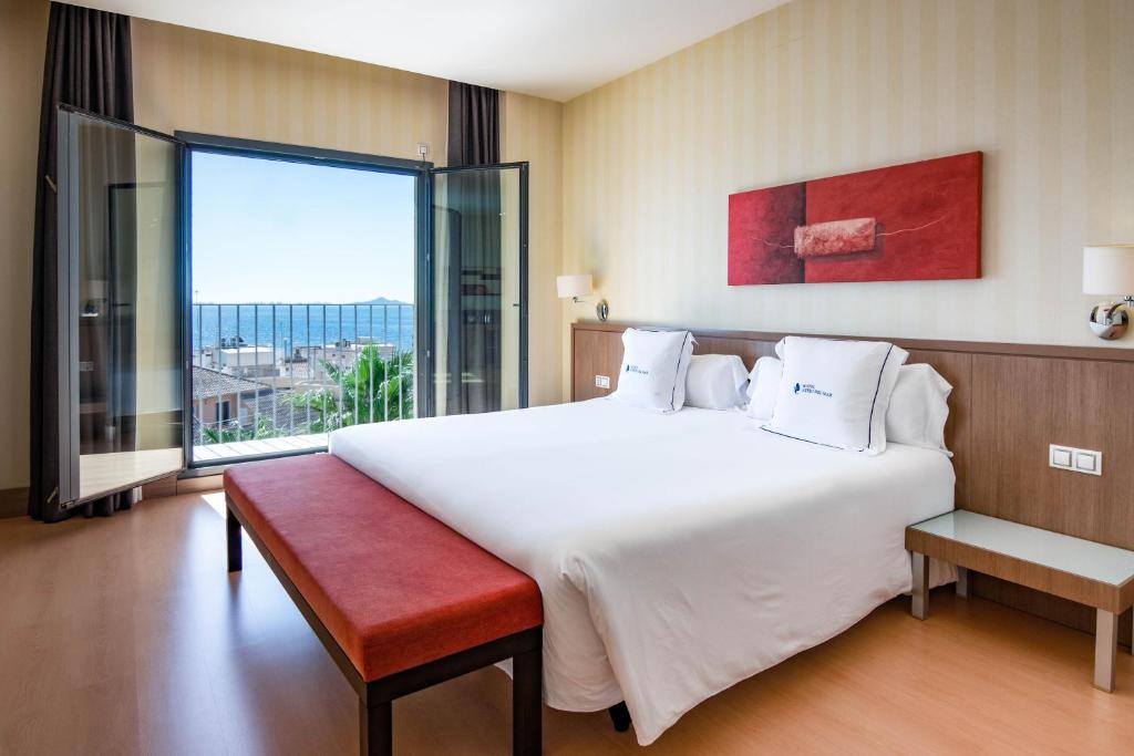 Cama blanca grande en habitación con ventana grande en Hotel Ibersol Atrio del Mar, en Los Alcázares