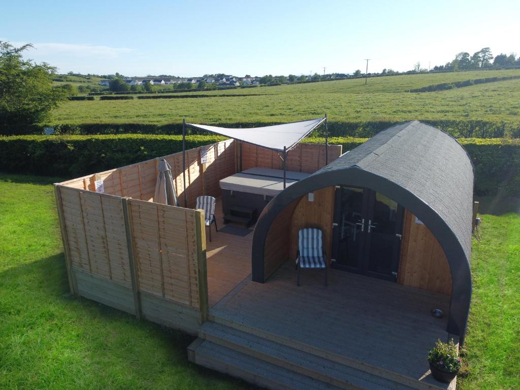 a gazebo with a table and chairs on a field at Fulshaw Mill Holidays in Stewarton