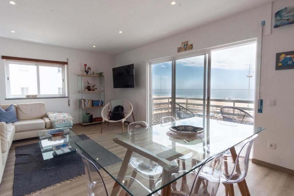 uma sala de estar com vista para o oceano em Apartamento Mar e Sol na Nazaré