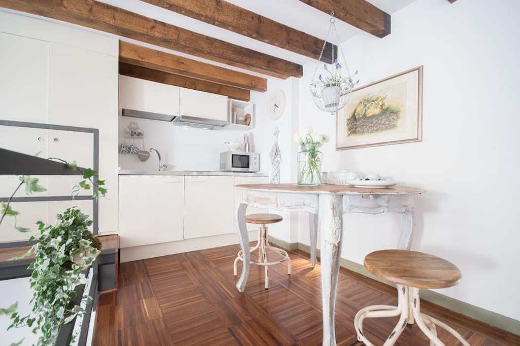 a kitchen with a table and two stools at Romantic loft Porta Venezia MILAN in Milan