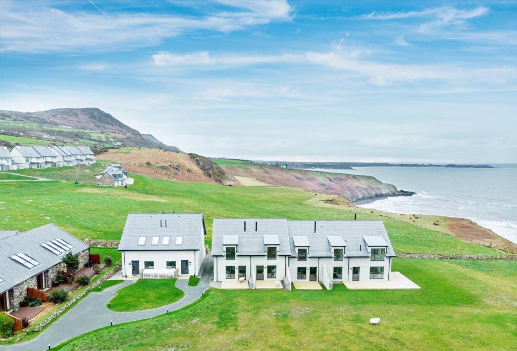 - une vue aérienne sur une maison située sur une colline à côté de l'océan dans l'établissement Porth Oer, à Nefyn