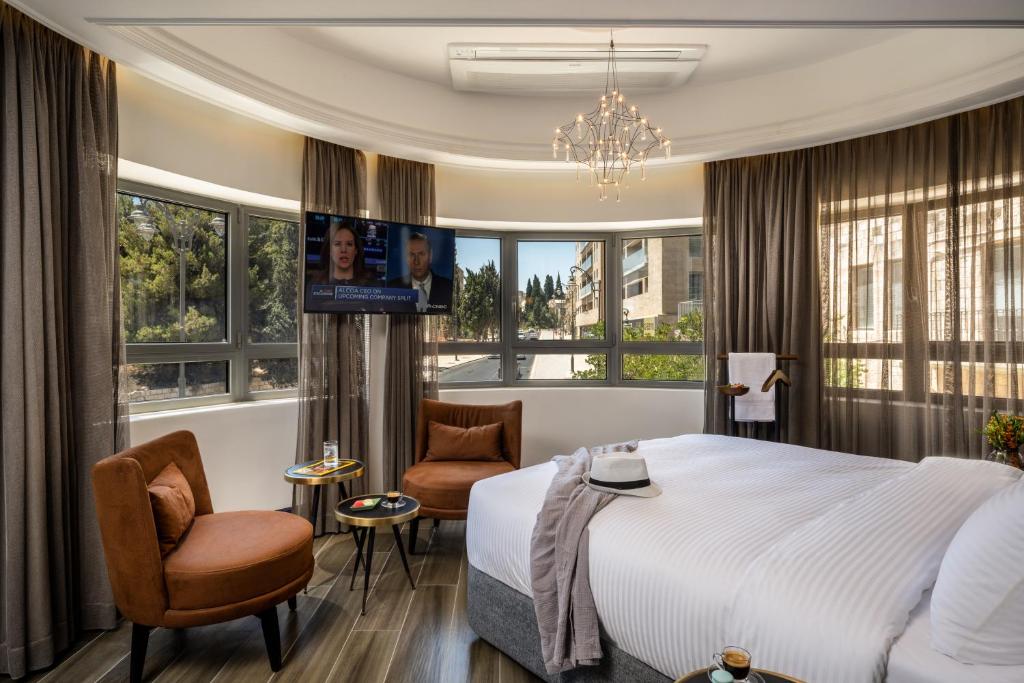 a hotel room with a bed and two chairs at The David Story Boutique in Jerusalem