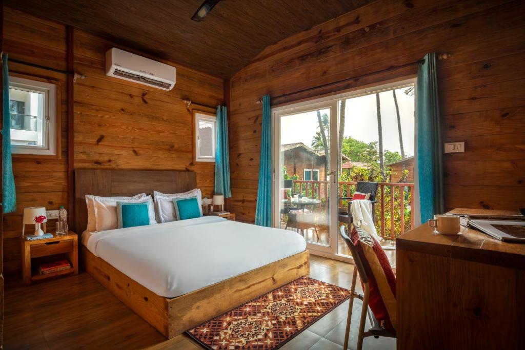 a bedroom with a bed and a balcony at Mariners Bay Beach Resort in Arambol