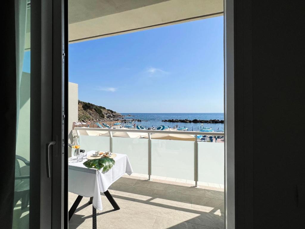a table on a balcony with a view of the ocean at Hotel Rex in Livorno