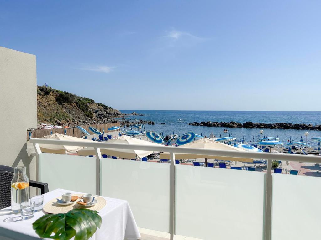a table on a balcony with a view of the ocean at Hotel Rex in Livorno