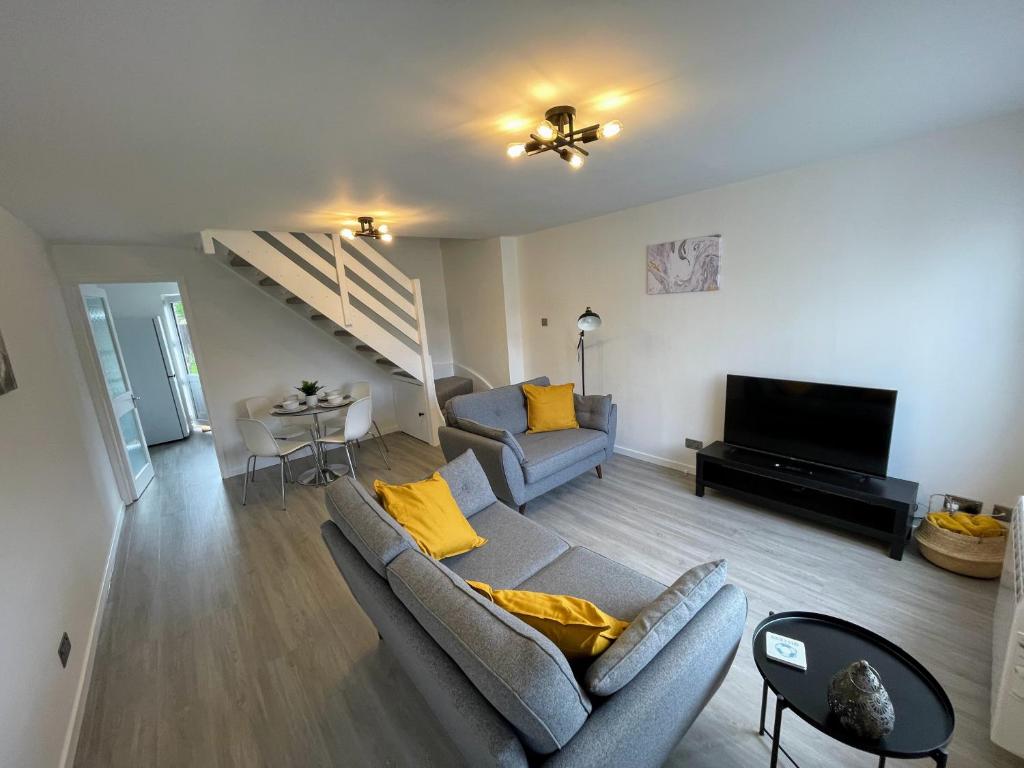 a living room with a couch and a television at High Tide House in Christchurch
