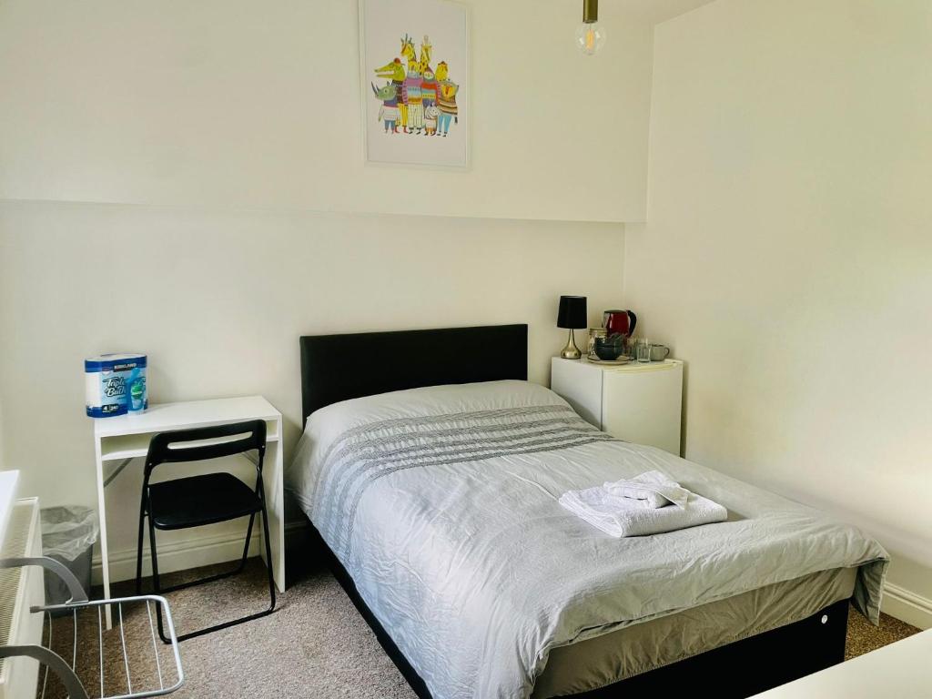 a small bedroom with a bed and a desk at 305 High Town Road in Luton