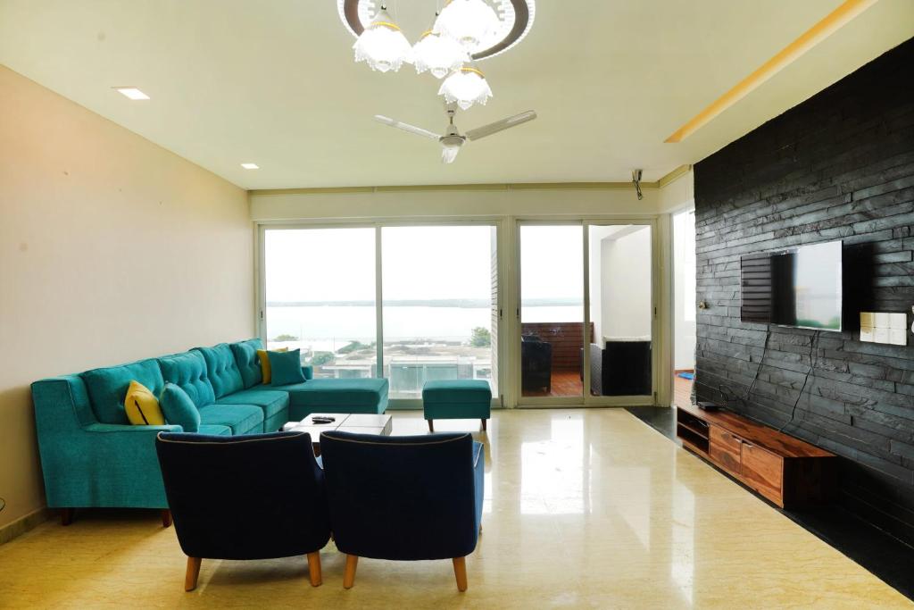 un soggiorno con divano blu e tavolo di St Jacinto Island Villa By JadeCaps- Bay View and Infinity Pool Near Goa Airport a Dabolim