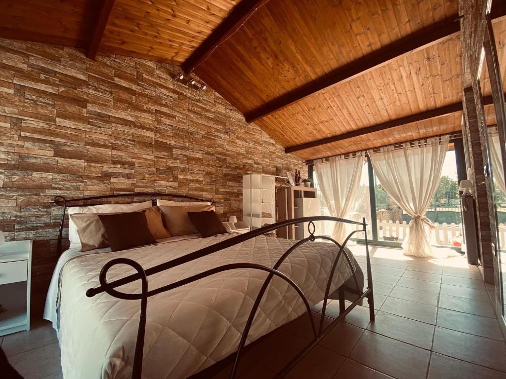 - une chambre avec un lit et un mur en briques dans l'établissement B&B Il Sentiero, à San Sperate