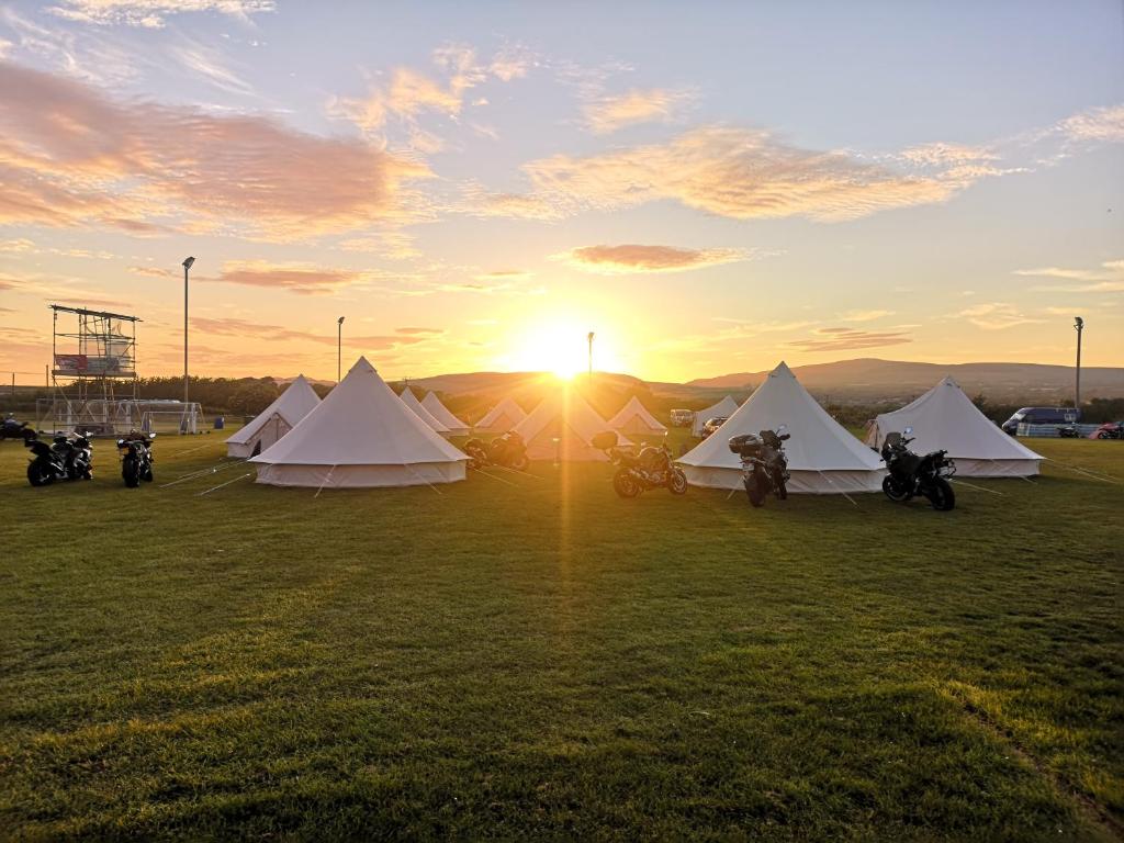 eine Gruppe von Motorrädern, die auf einem Feld mit Zelten geparkt werden in der Unterkunft Nine Yards Bell Tents at the TT in Castletown