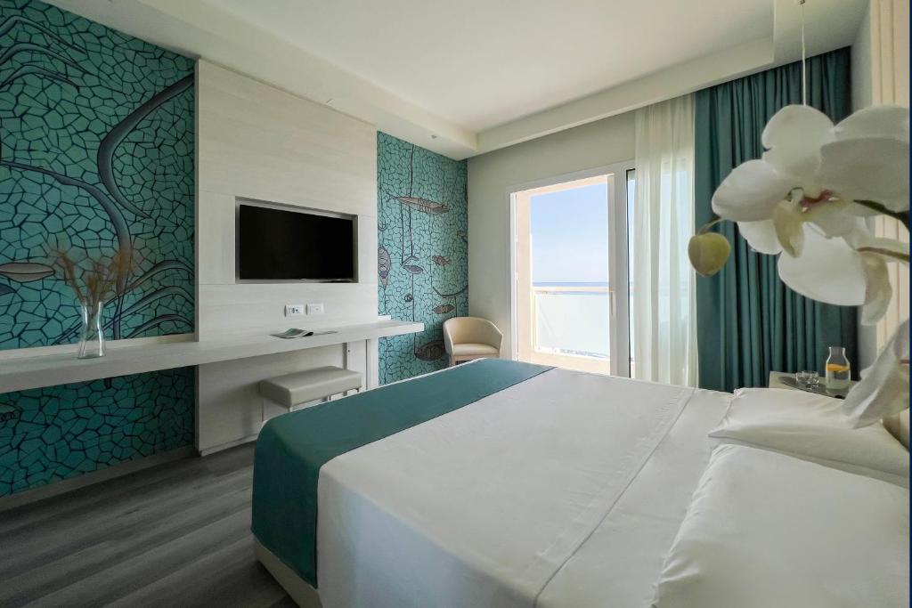 1 dormitorio con 1 cama grande y TV en Hotel Rex en Livorno