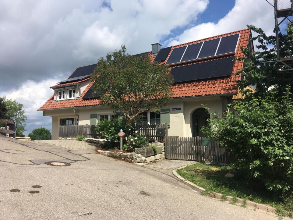 una casa con paneles solares en el techo en Ferienwohnung am Glockenturm, en Weissenburg in Bayern