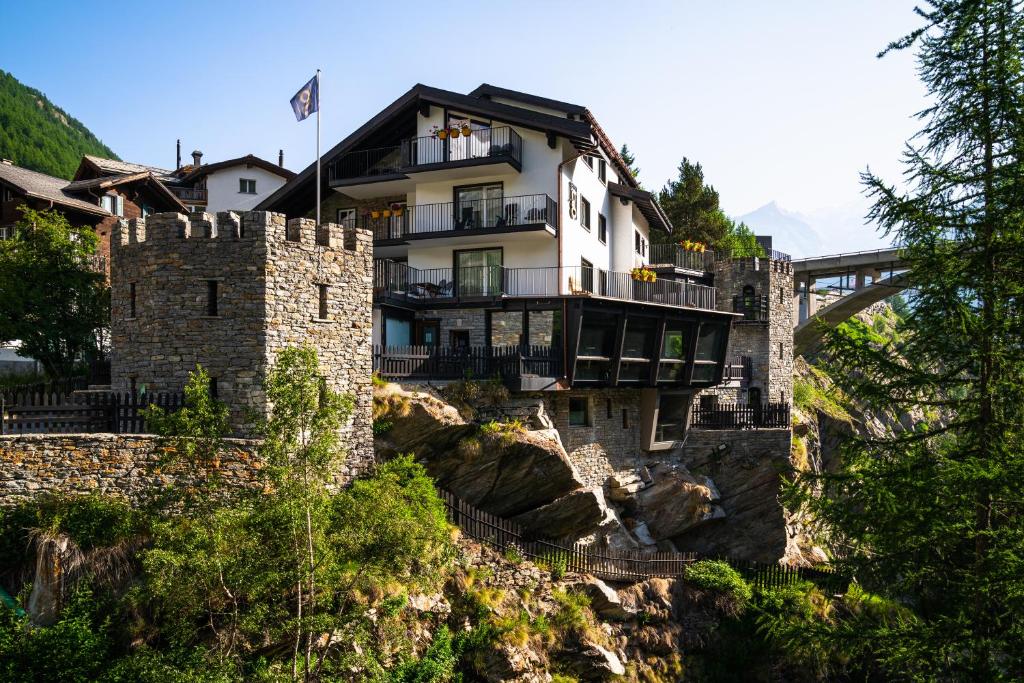 a building on top of a mountain with a bridge at Boutique Hotel La Gorge in Saas-Fee