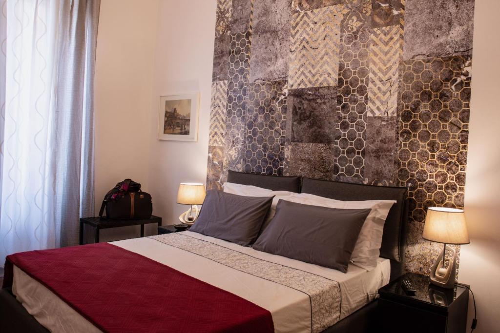 ローマにあるMonticello apartment via Cavourのベッドルーム1室(大型ベッド1台、ランプ2つ付)