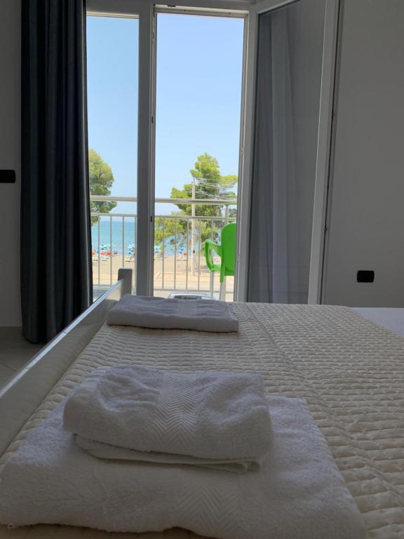uma cama com toalhas com vista para o oceano em Sunny Breeze Shengjin em Shëngjin