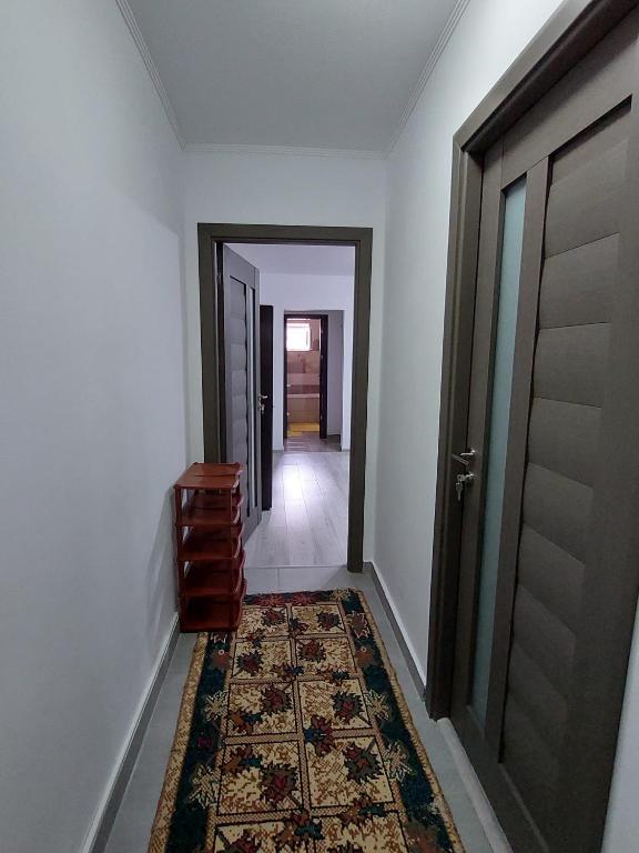 an empty hallway with a door and a rug at Apartament Beatrice in Năvodari