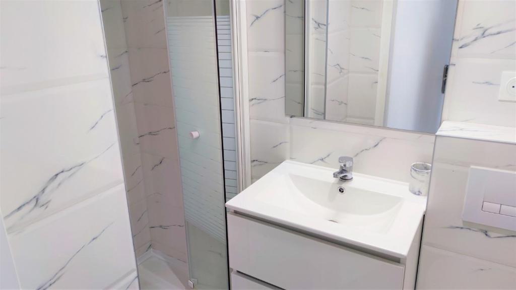 a white bathroom with a sink and a shower at Delille centre ville 14 in Nice