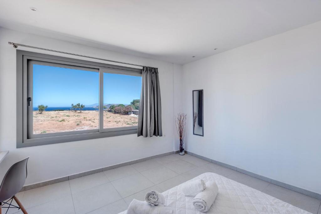 En eller flere senger på et rom på Chrysonisos Suites with Sunset & Seaviews near Kini