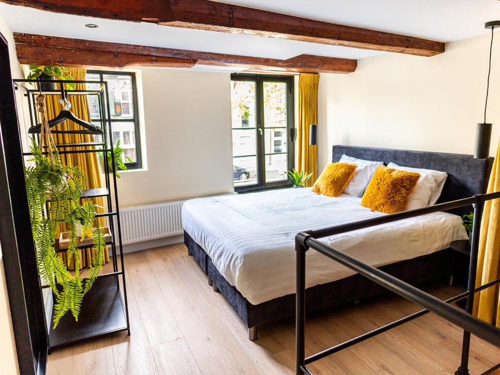 een slaapkamer met een bed en een aantal planten bij Appartement Wolf in Alkmaar