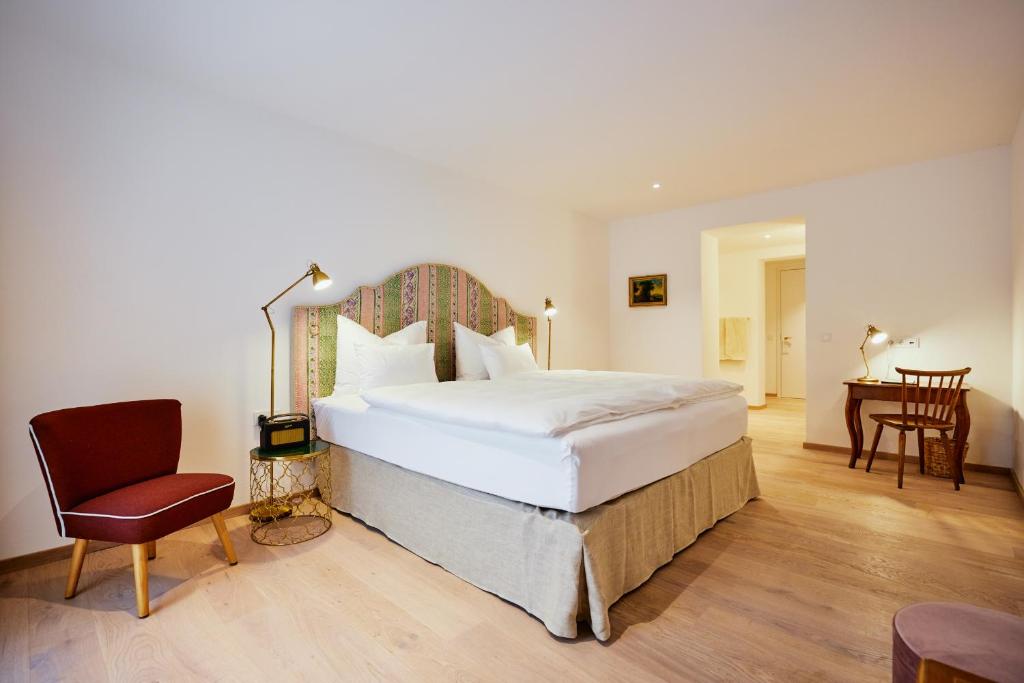 a bedroom with a bed and a desk and a chair at Boutiquehotel Zum Goldenen Hirschen in Gmunden