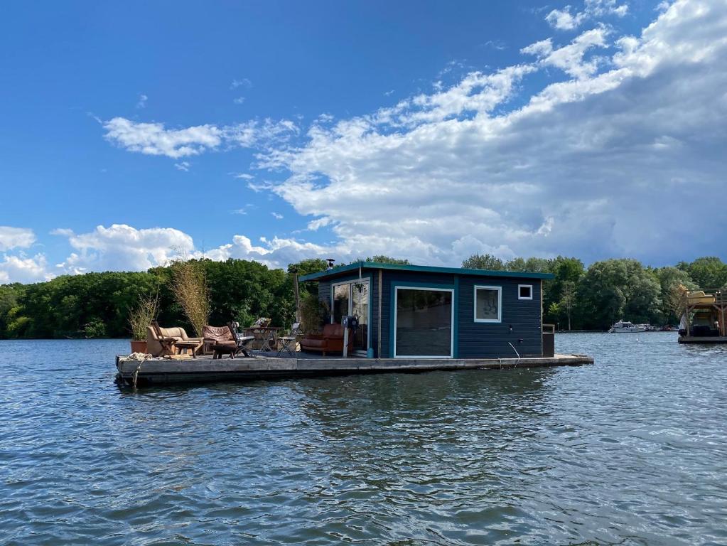 a tiny house on a dock in the water at Großes gemütliches Hausboot in Berlin in Berlin