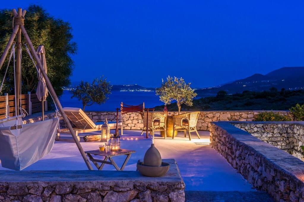 a patio with a hammock and chairs at night at Villa Zoi in Koríthion
