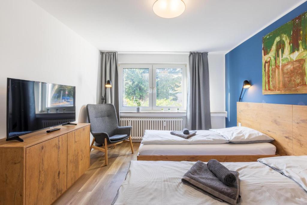 Habitación de hotel con 2 camas y TV en Glück Auf Appartements Am Stadtpark Duisburg, en Duisburg