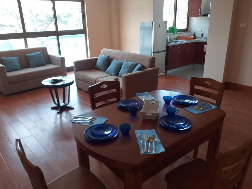 uma cozinha e sala de estar com uma mesa de madeira e uma sala de jantar em Queen M Palace em Addis Ababa