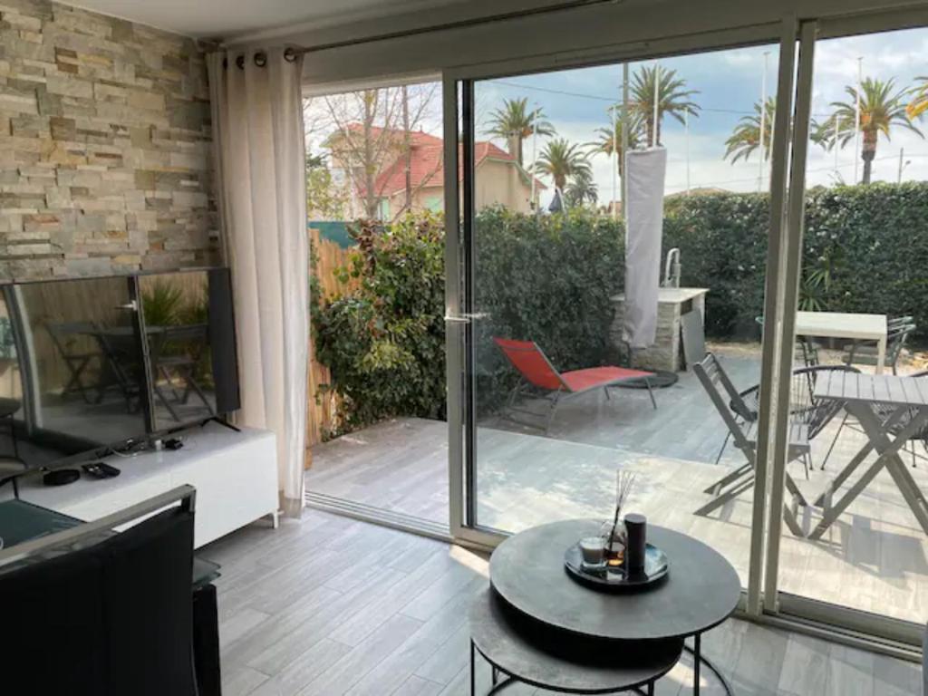 una sala de estar con puertas correderas de cristal en LE PLEIN SUD A DEUX PAS DE LA PLAGE, en Saint-Cyr-sur-Mer