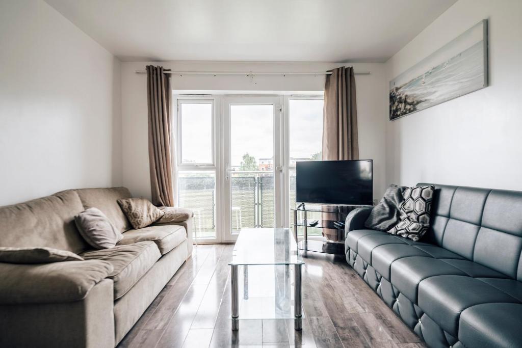 a living room with two couches and a television at Lloyd St Apartment in Manchester