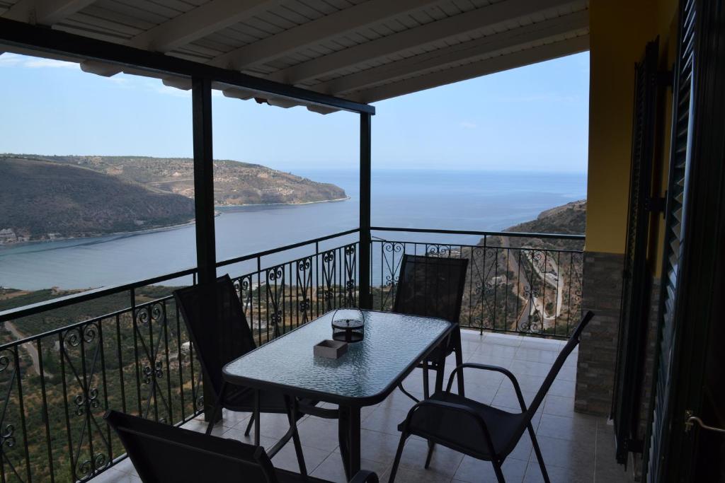 un tavolo e sedie su un balcone con vista sull'oceano di Frygano Apartments 2 a Oitylo