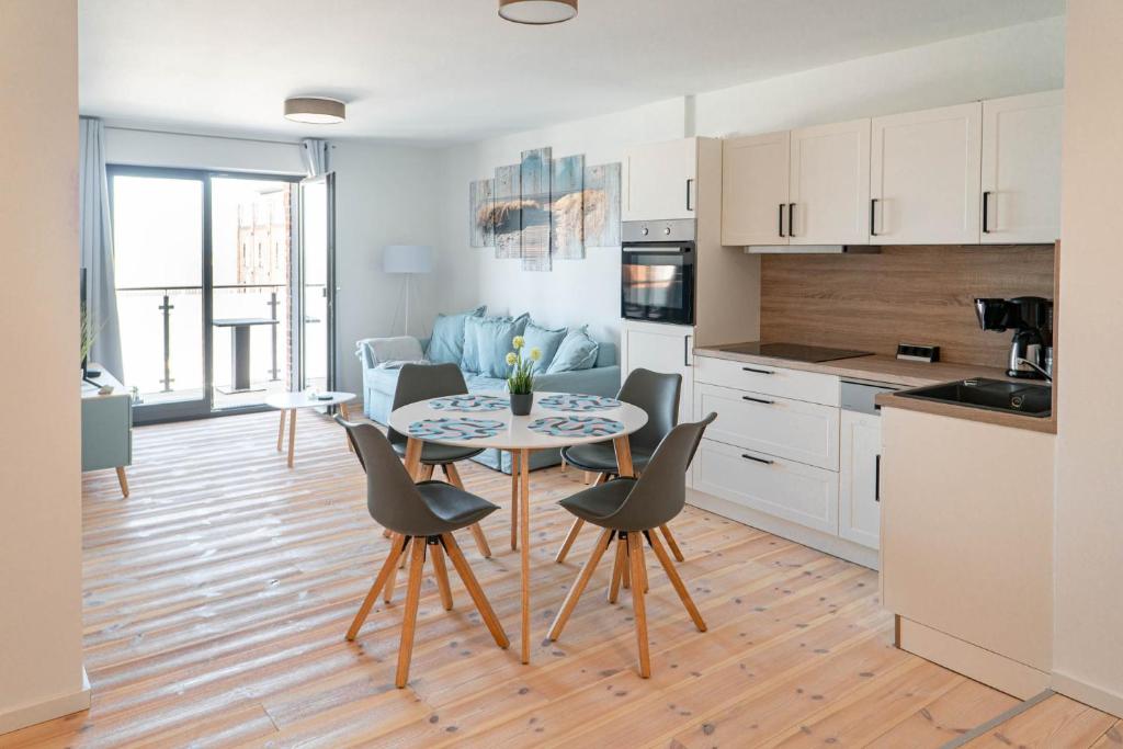een keuken en een woonkamer met een tafel en stoelen bij Boddenkieker in Barth