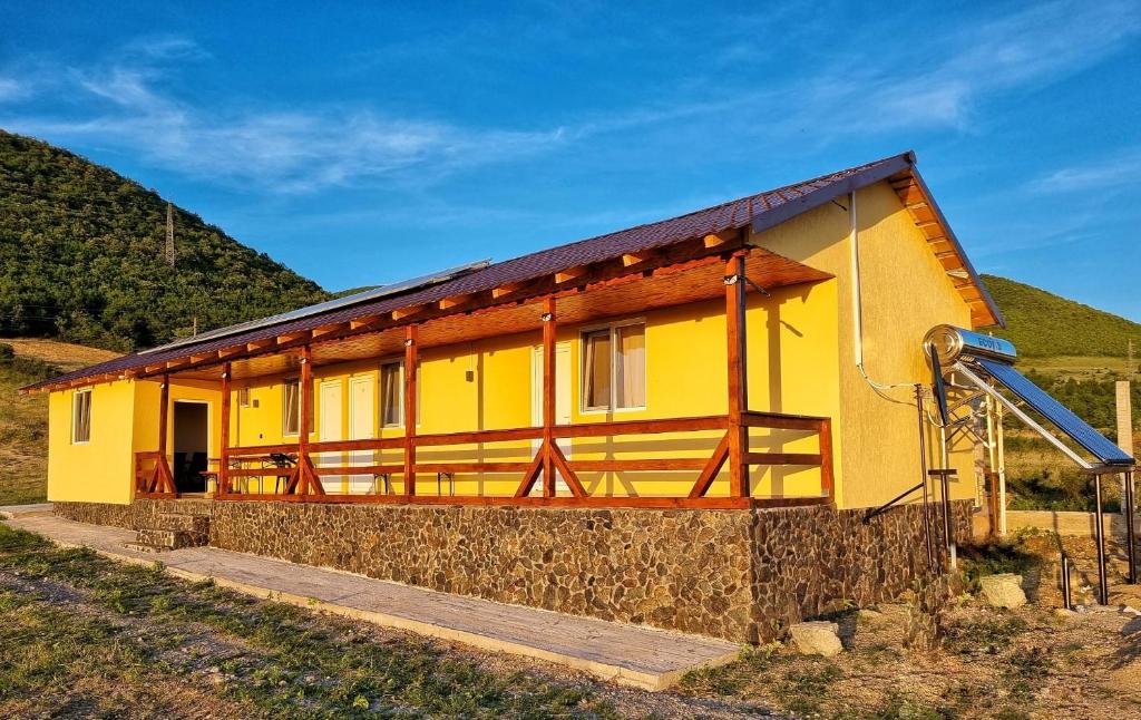 Moldova Veche的住宿－Cabana Vărad Coronini，山坡上带滑梯的黄色房子