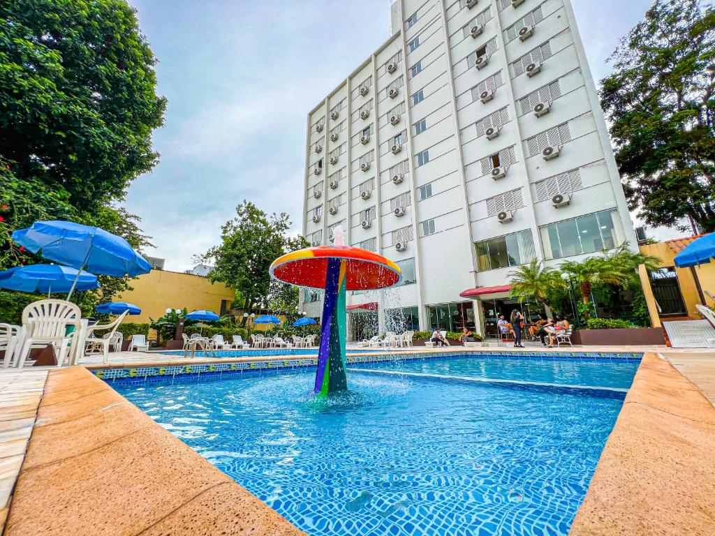 uma piscina com uma fonte no meio de um edifício em San Juan Tour em Foz do Iguaçu