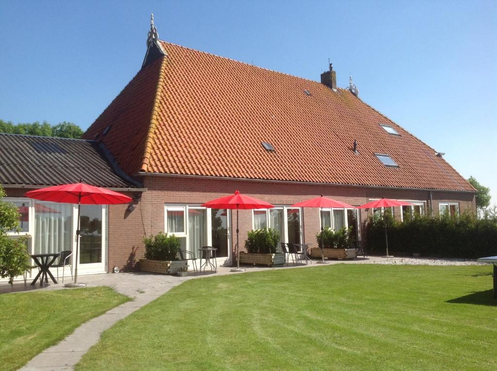 a house with red umbrellas in a yard at Cecilia - Catharina B&B in Joure