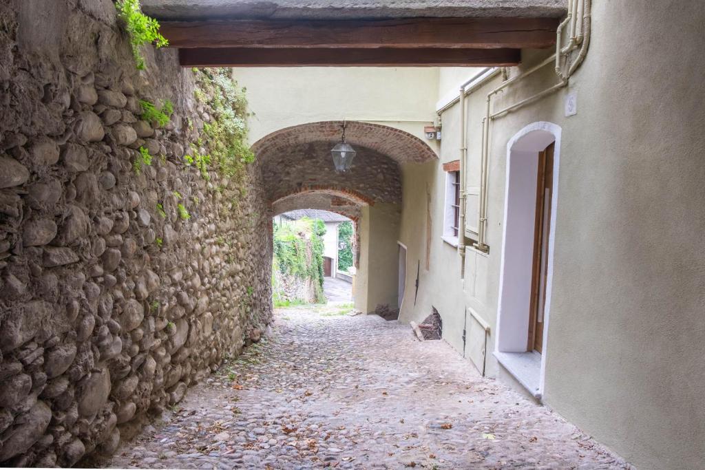 eine Gasse in einem alten Gebäude mit Torbogen in der Unterkunft Residenza LA FINESTRA SUL MAIRA in Dronero