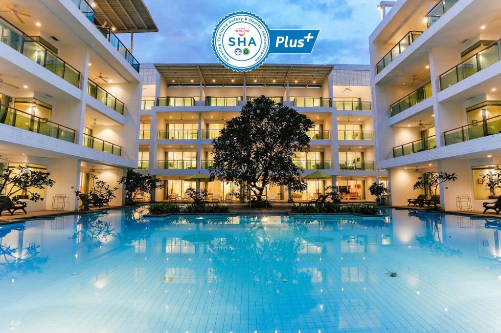 a large swimming pool in front of a hotel at The Old Phuket - Karon Beach Resort - SHA Plus in Karon Beach